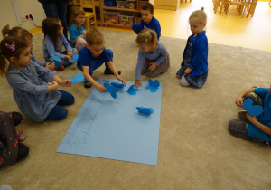 11 Dzieci przyklejają niebieskie motyle.